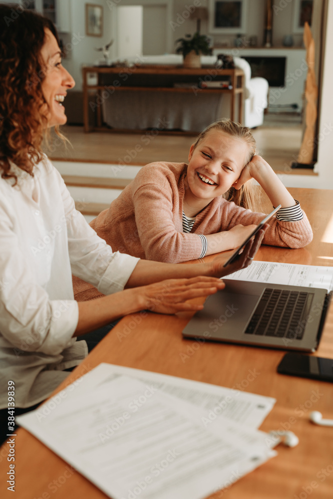 Woman giving attention to her daughter while working at home