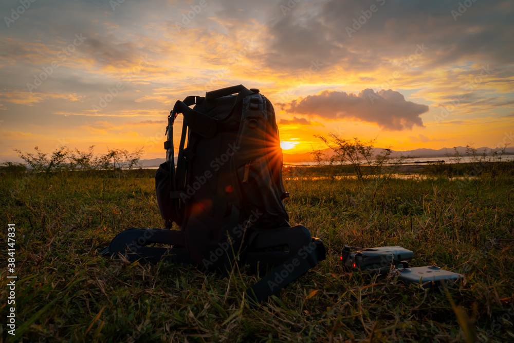 bagpack and drone with sun set