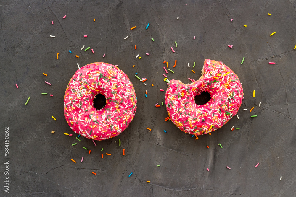 Pink berry donuts flat lay, top view. Glazed and sprinkles doughnuts