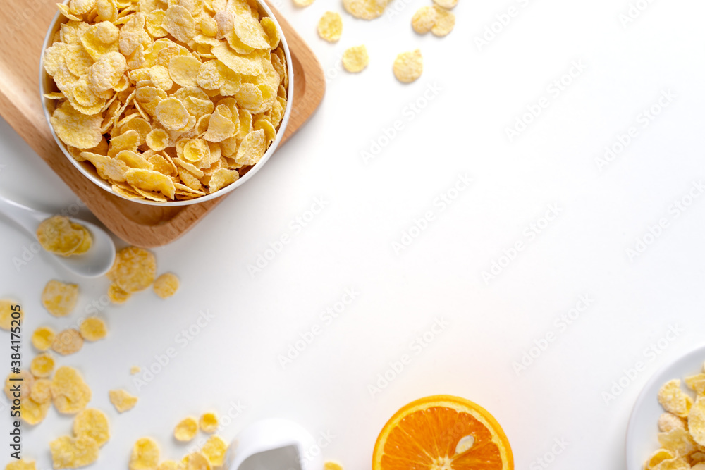 Top view of corn flakes bowl with milk on white background.