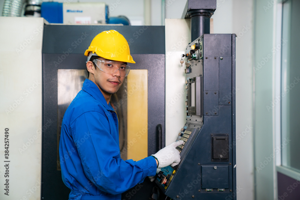 Mechanical technician operative entering data in cnc milling cutting machine at factory at tool work