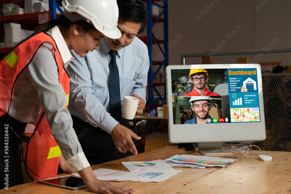 Warehouse staff talking on video call at computer screen in storage warehouse . Online software tech