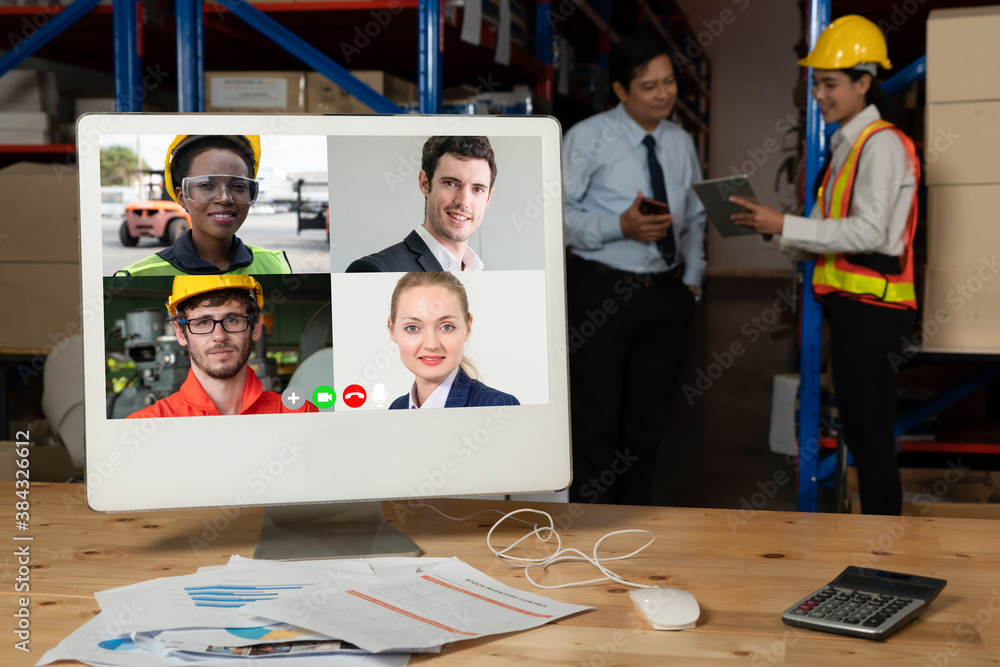 Warehouse staff talking on video call at computer screen in storage warehouse . Online software tech