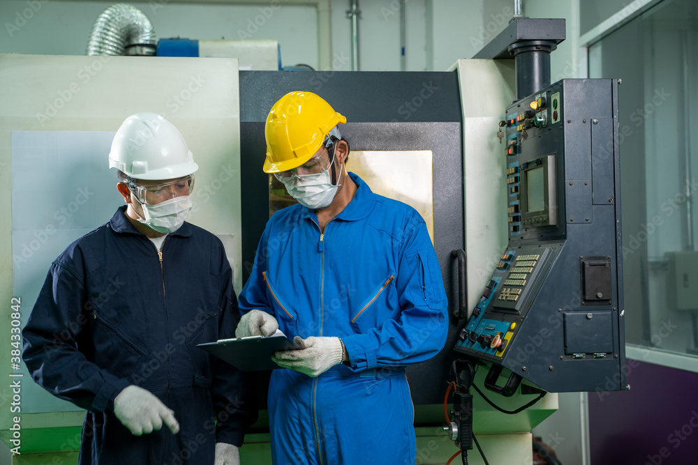 Industrial factory employee working and checking near electric meters panel of a control room in ind