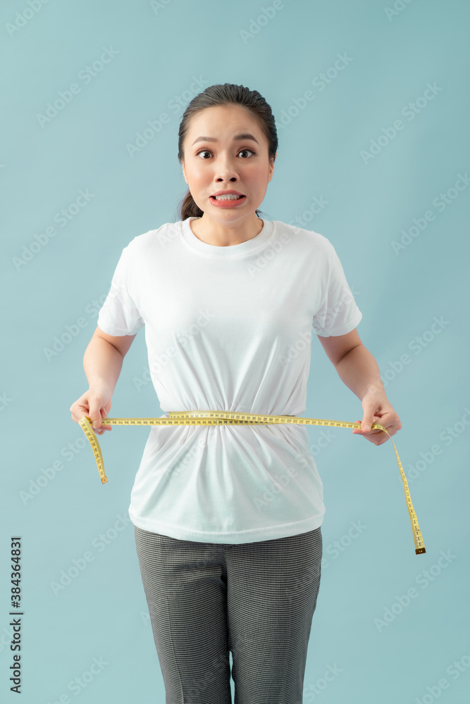 astonished slim woman measuring her waist