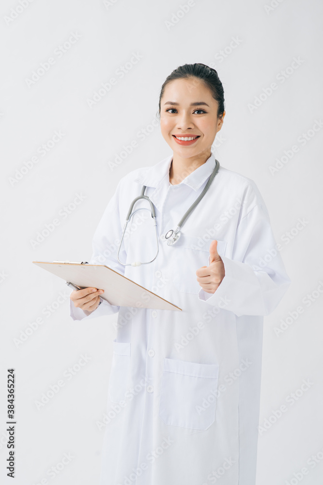 Portrait of an attractive young female doctor or nurse in white uniform with stethoscope holding med