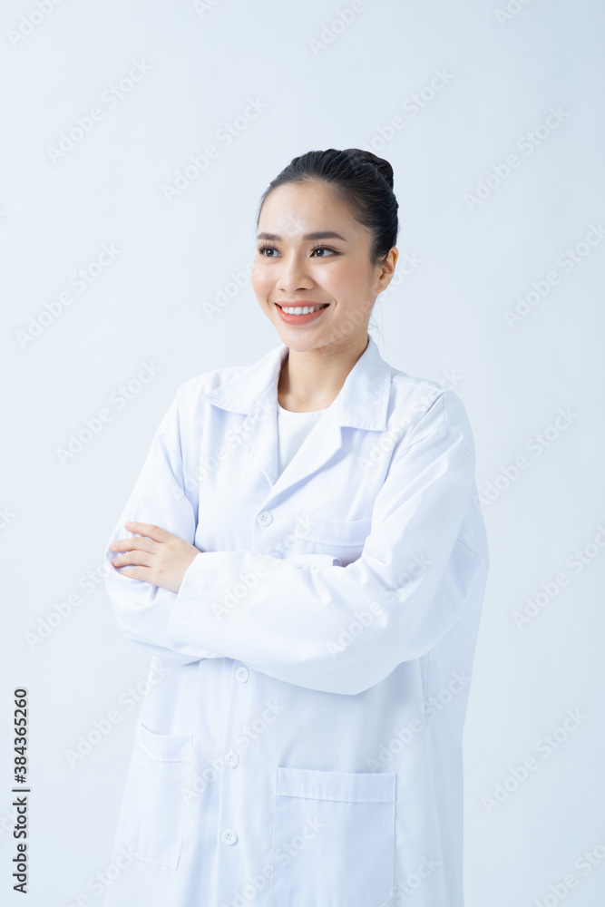 Portrait of glad smiling doctor in white uniform standing with crossed hands on white background