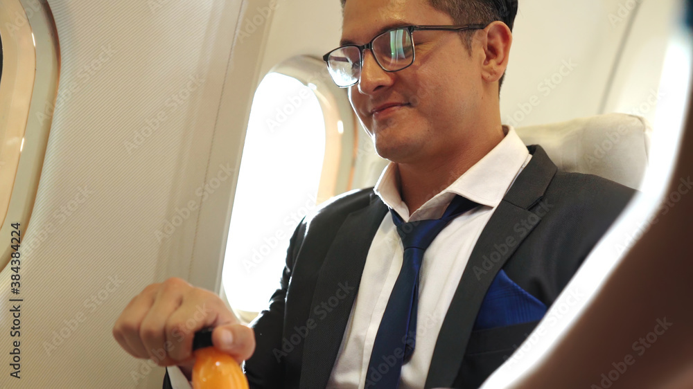 Businessman have orange juice served by an air hostess in airplane . Business trip travel concept .