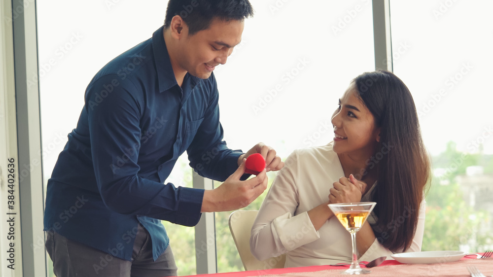 Romantic couple giving gift to lover at restaurant . Happy couple lifestyle .