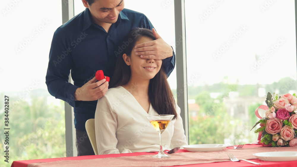 Romantic couple giving gift to lover at restaurant . Happy couple lifestyle .