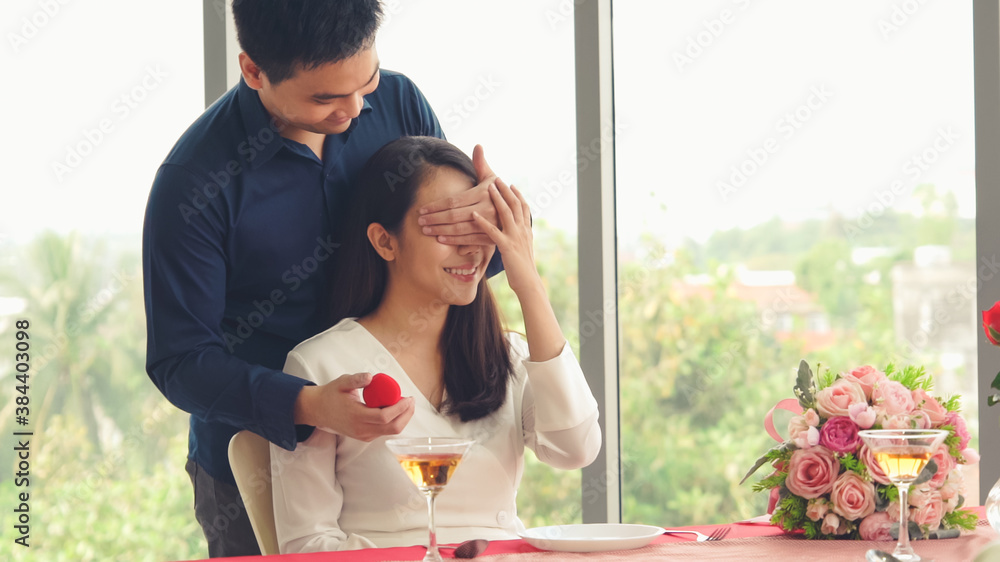 Romantic couple giving gift to lover at restaurant . Happy couple lifestyle .