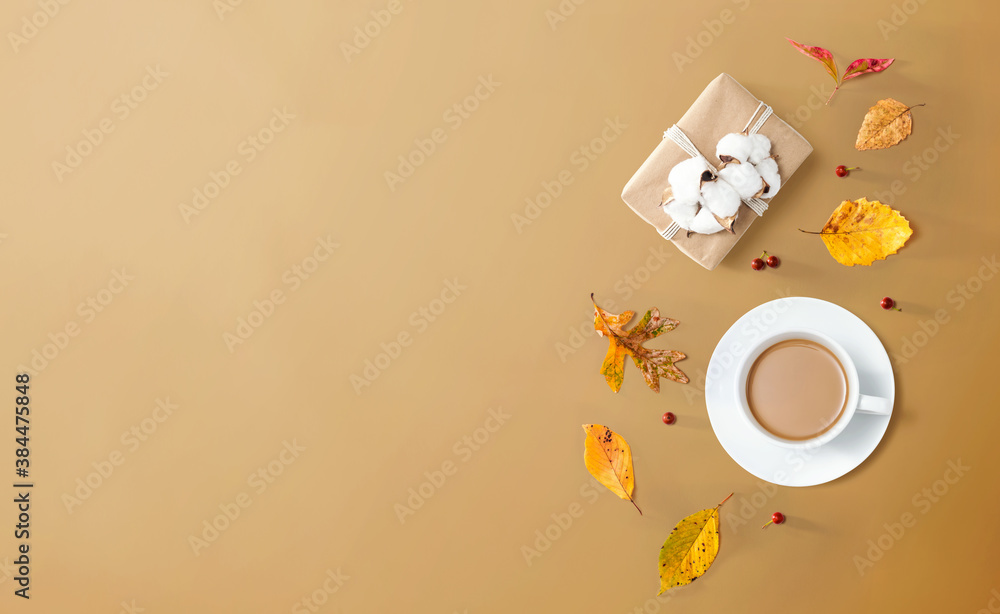 Autumn theme with a cup of coffee and a gift box - overhead view