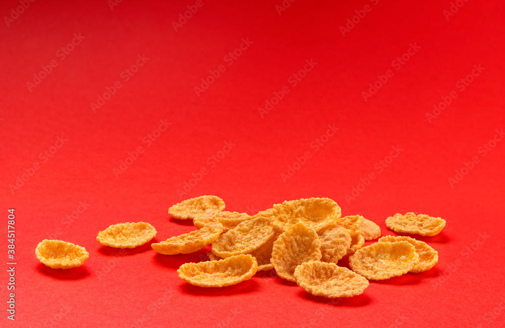 Corn flakes isolated on red color background, full depth of field