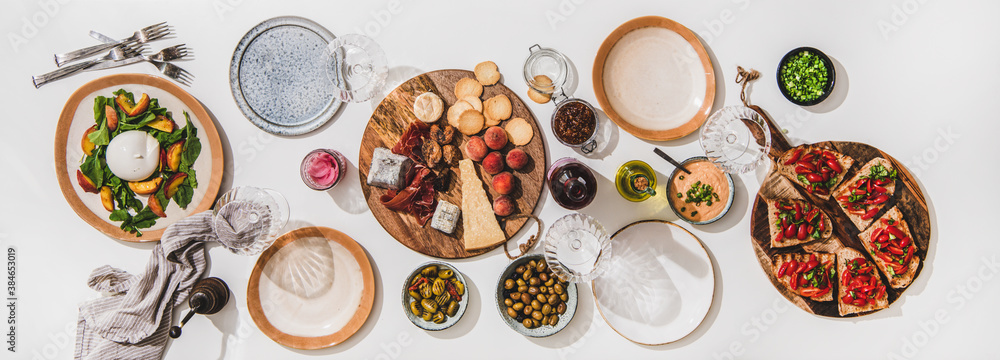 Family wine and snack party. Flay-lay of wineglases, boards with cheese, fruit, smoked meat, tomato 