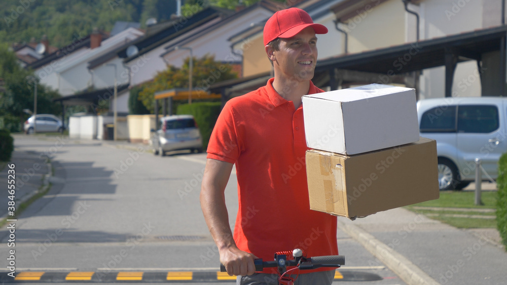 COPY SPACE: Smiling courier rides e-scooter down the street with two packages