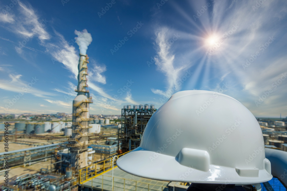 helmet in Industrial oil and gas refinery plant form industry zone with sunrise and cloudy sky, safe