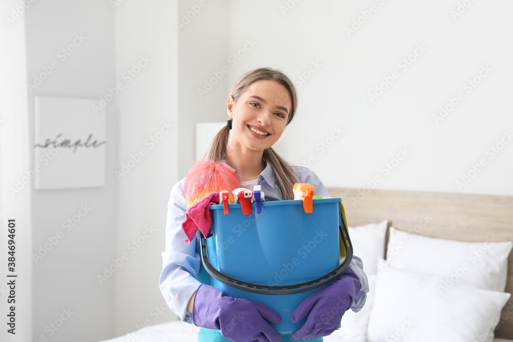 Young woman with cleaning supplies at home