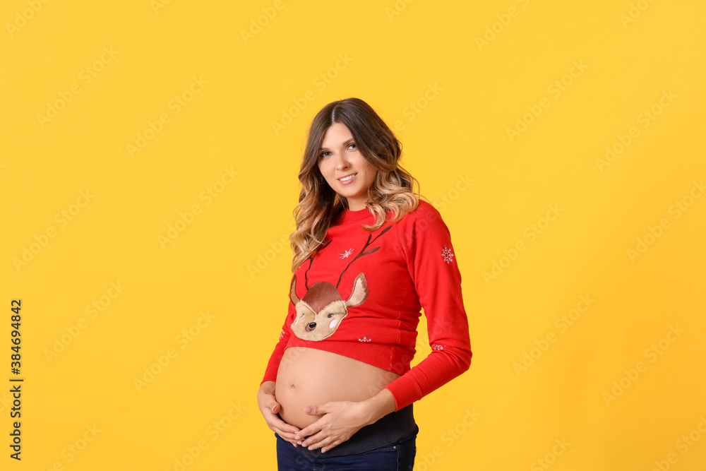 Beautiful pregnant woman on color background. Christmas celebration