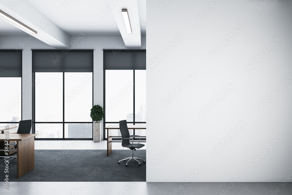 Clean office room with computers, blank white wall