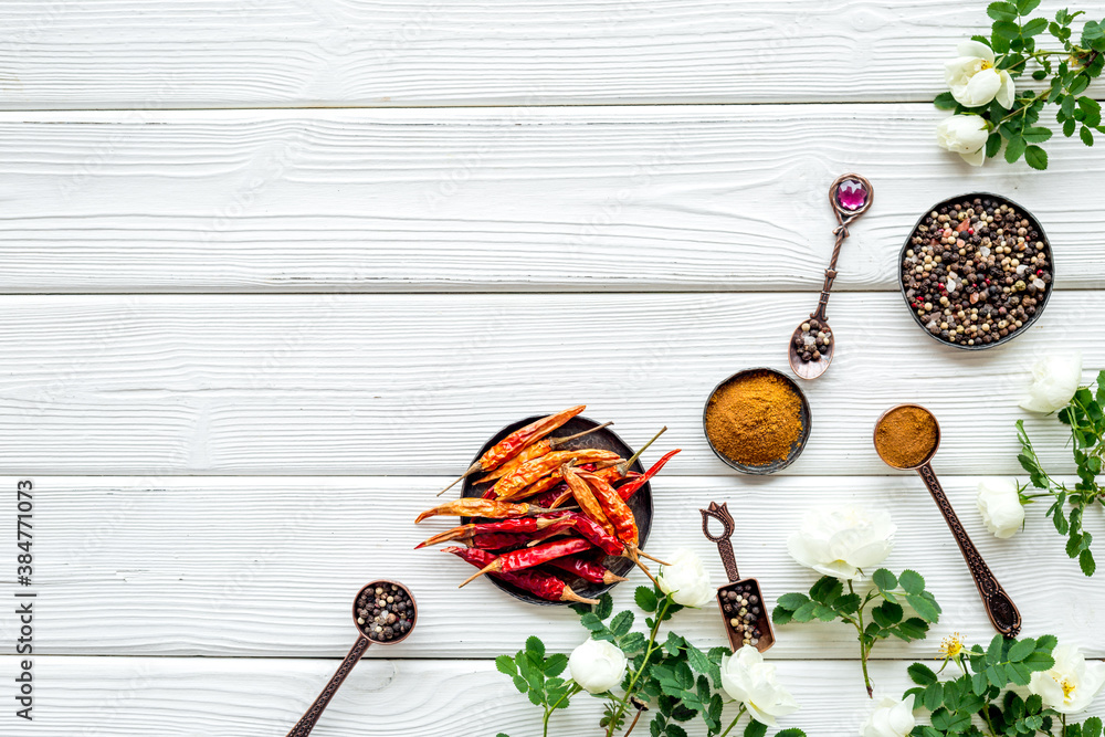 Set of spices and herbs for cooking in metal spoons and bowls, top view