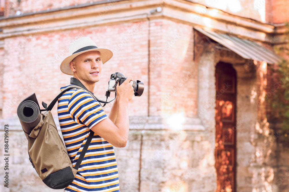 Male tourist taking photo on city street