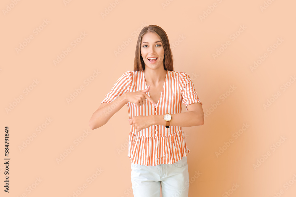 Young woman with wristwatch on color background