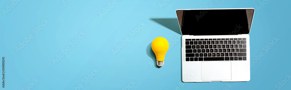 Laptop computer with a yellow light bulb from above