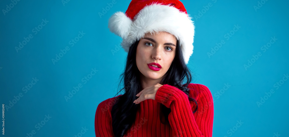 Young woman with Santa hat thoughtful pose on a dark blue background