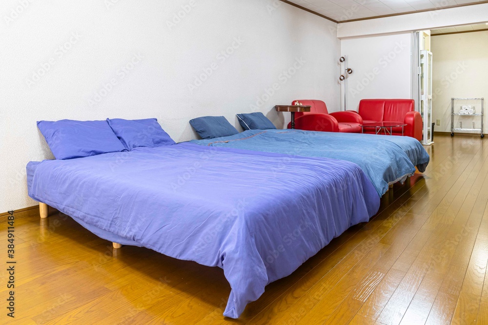 A large double bed and a blue bedspread in the bedroom of the apartment