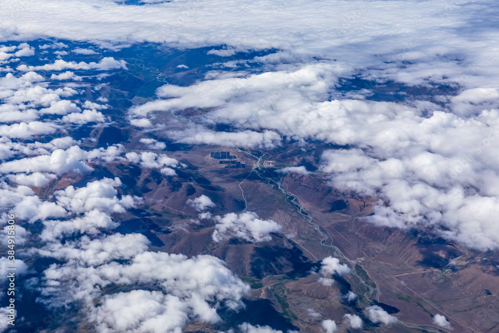 Aerial view above the clouds and mountain peaks on a sunny day.mountain view from airplane.