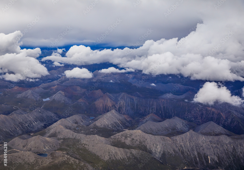 Aerial view above the clouds and mountain peaks on a sunny day.mountain view from airplane.