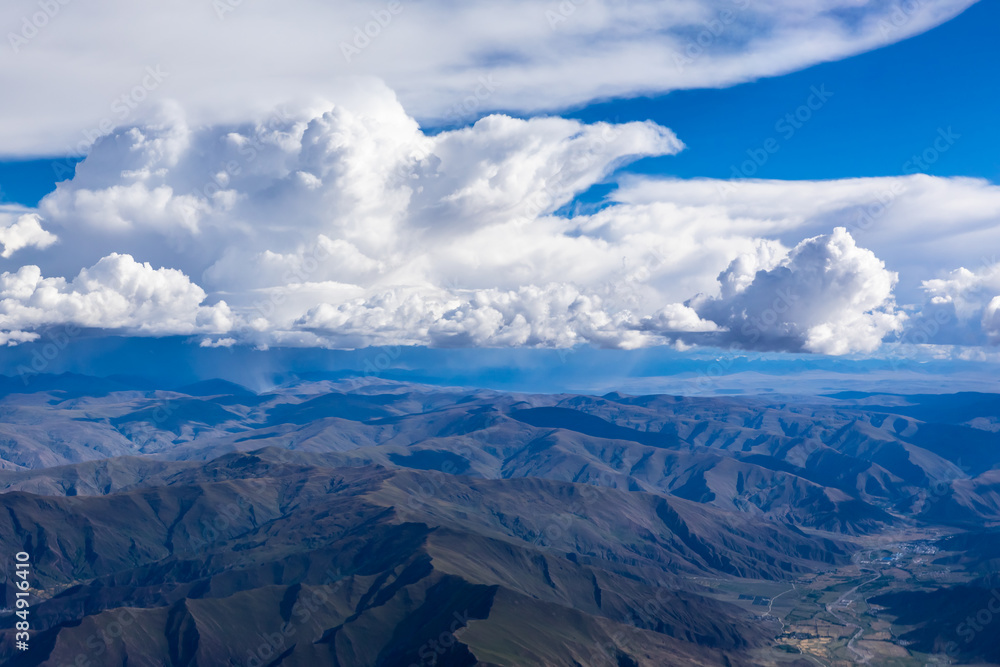 Aerial view above the clouds and mountain peaks on a sunny day.mountain view from airplane.