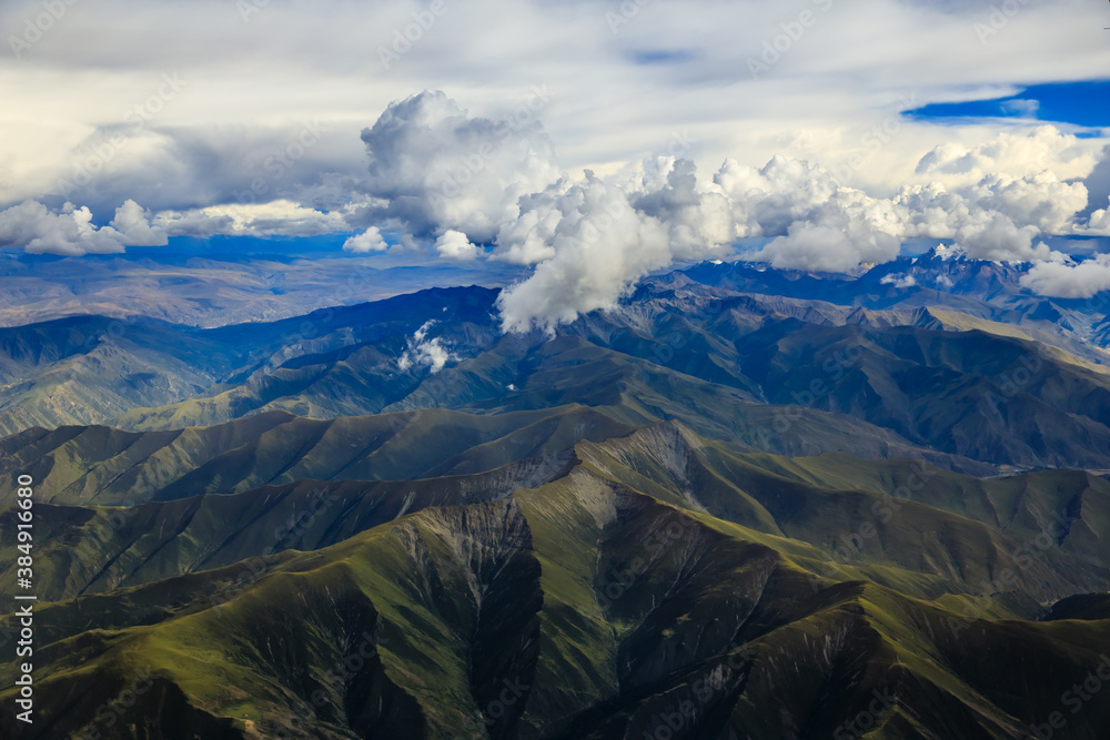 Aerial view above the clouds and mountain peaks on a sunny day.mountain view from airplane.