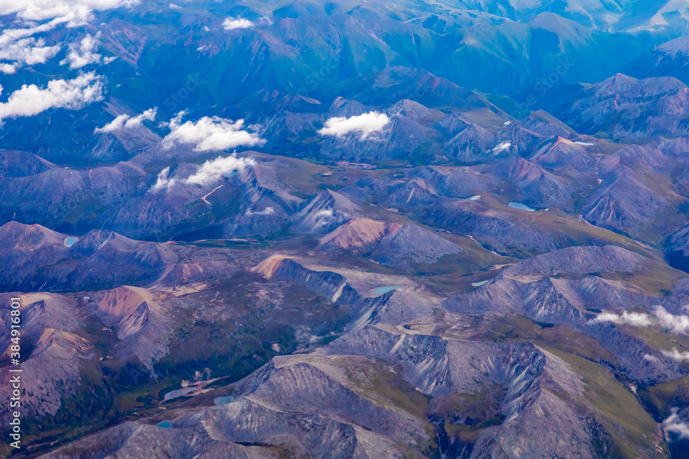 Aerial view above the clouds and mountain peaks on a sunny day.mountain view from airplane.