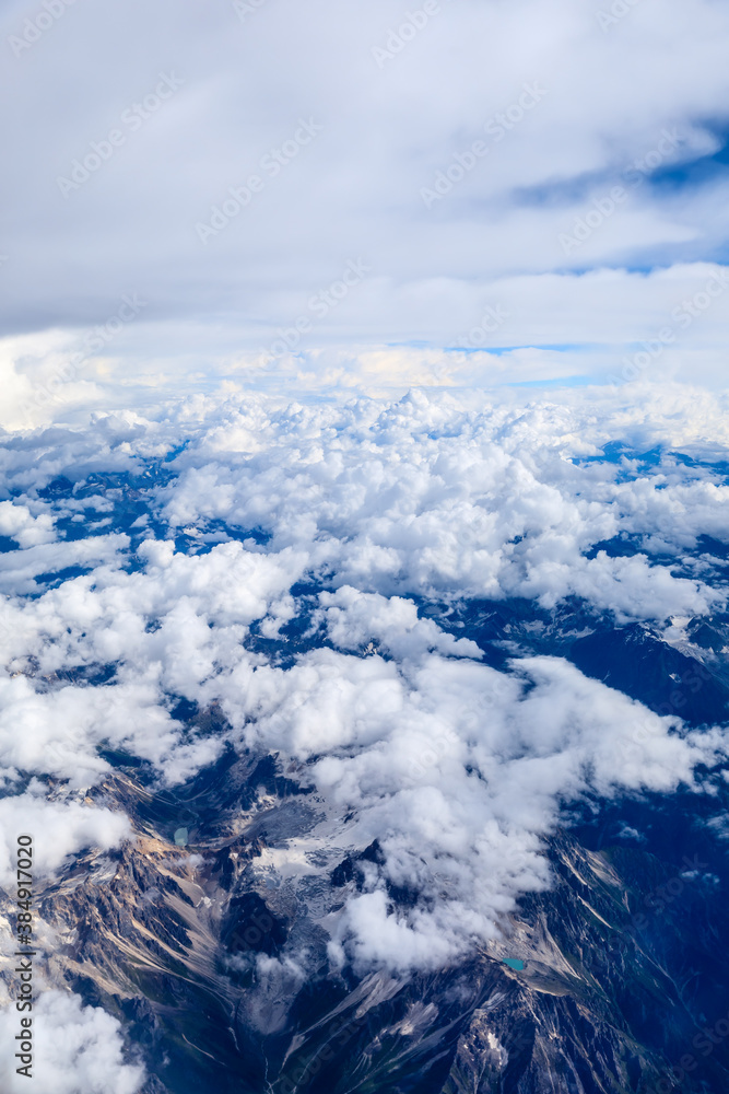 Aerial view above the clouds and mountain peaks on a sunny day.mountain view from airplane.