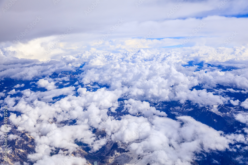 Aerial view above the clouds and mountain peaks on a sunny day.mountain view from airplane.