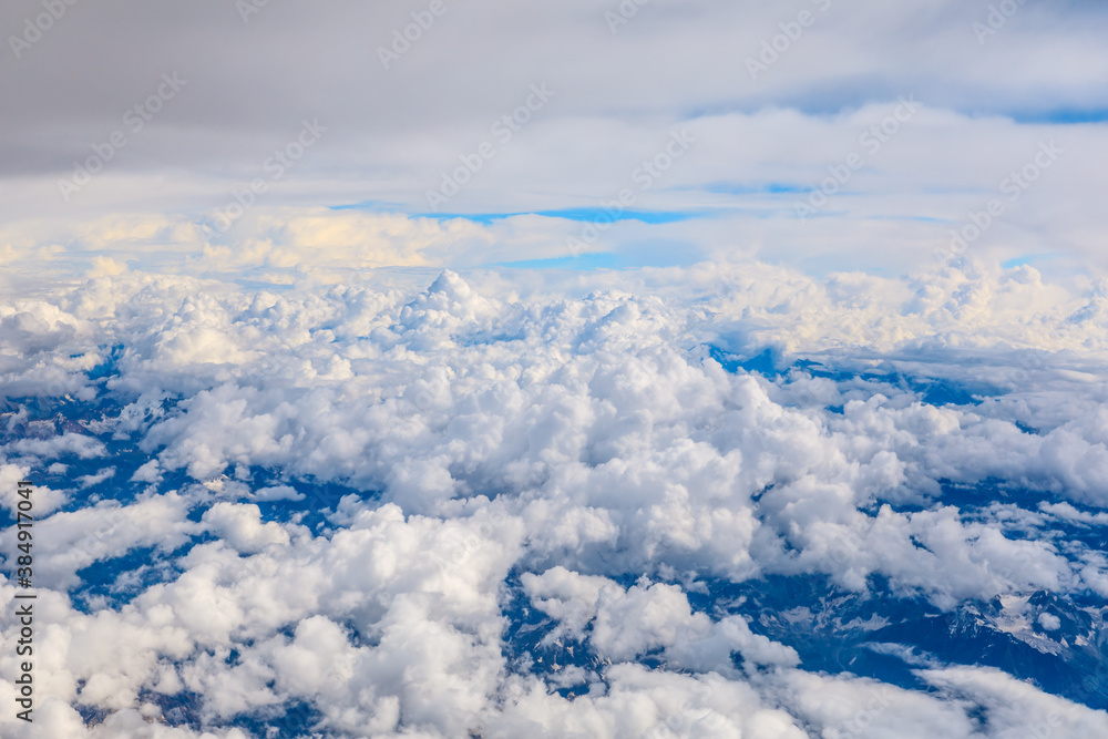 Aerial view above the clouds and mountain peaks on a sunny day.mountain view from airplane.