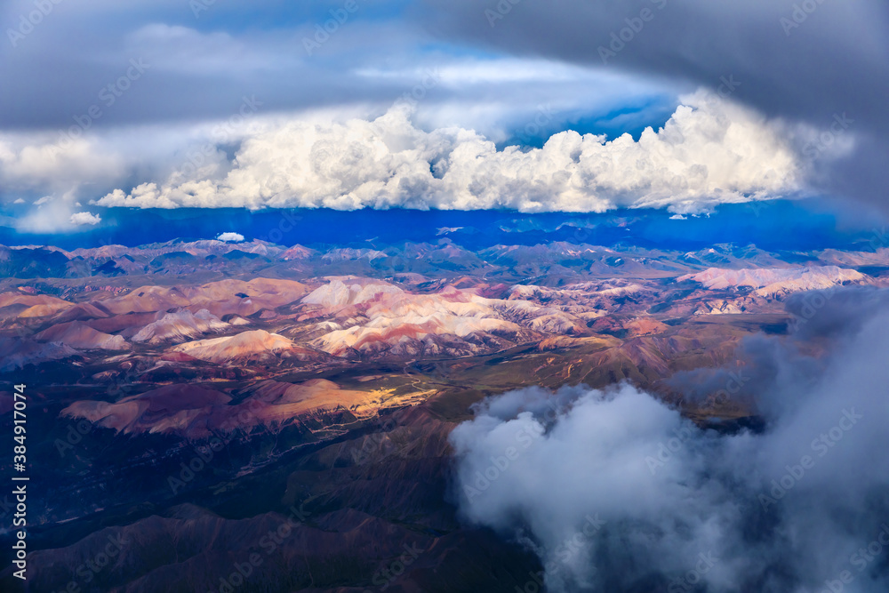 Aerial view above the clouds and colorful mountain on a sunny day.mountain view from airplane.