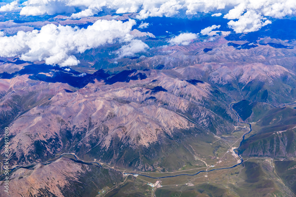 Aerial view above the clouds and mountain peaks on a sunny day.mountain view from airplane.