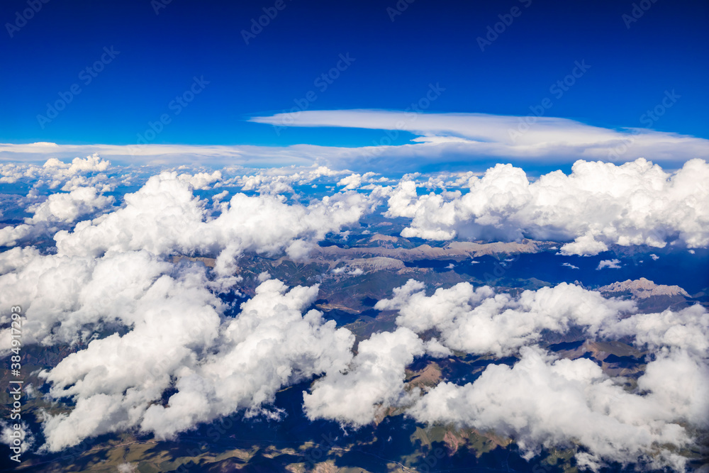 Aerial view above the clouds and mountain peaks on a sunny day.mountain view from airplane.