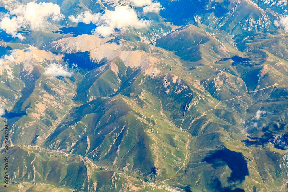 Aerial view above the clouds and mountain peaks on a sunny day.mountain view from airplane.