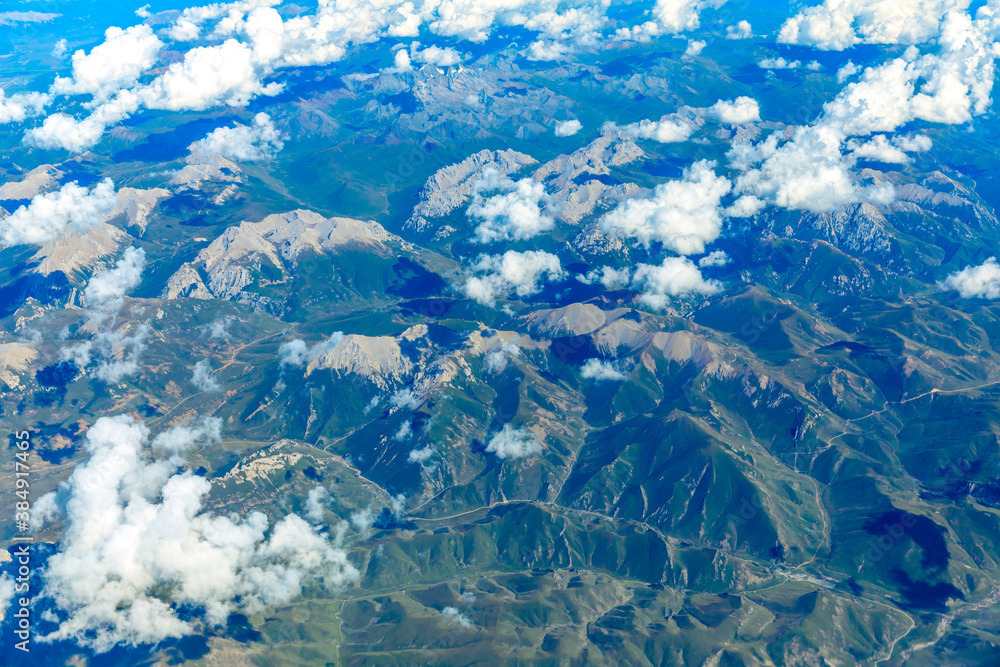 Aerial view above the clouds and mountain peaks on a sunny day.mountain view from airplane.