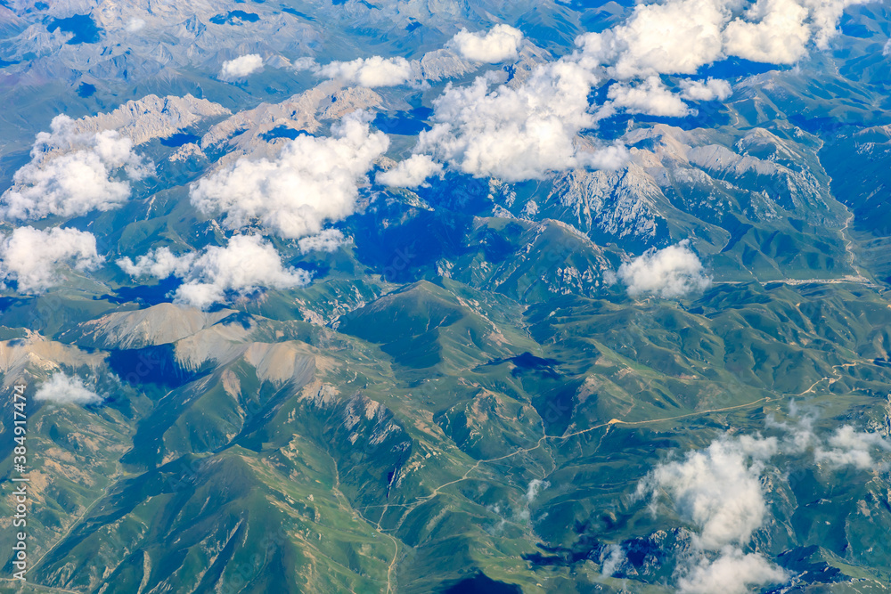 在阳光明媚的日子里俯瞰云朵和山峰。从飞机上俯瞰山景。