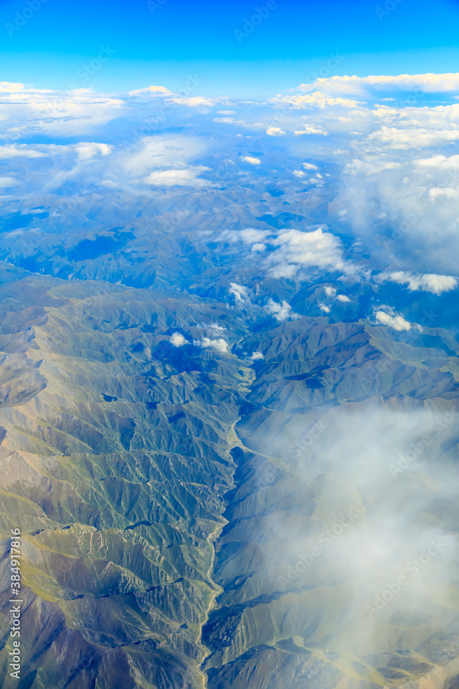 Aerial view above the clouds and mountain peaks on a sunny day.mountain view from airplane.