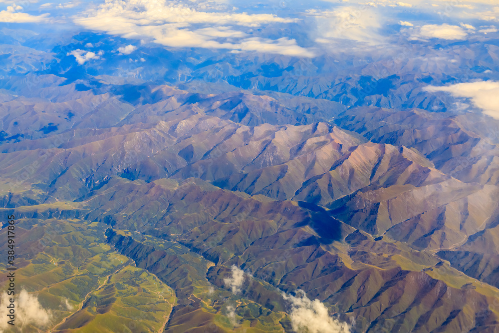 Aerial view above the clouds and mountain peaks on a sunny day.mountain view from airplane.