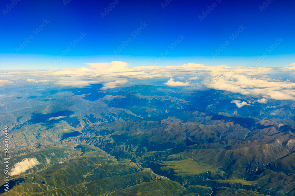 Aerial view above the clouds and mountain peaks on a sunny day.mountain view from airplane.