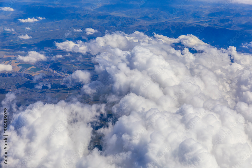 Aerial view above the clouds and mountain peaks on a sunny day.mountain view from airplane.