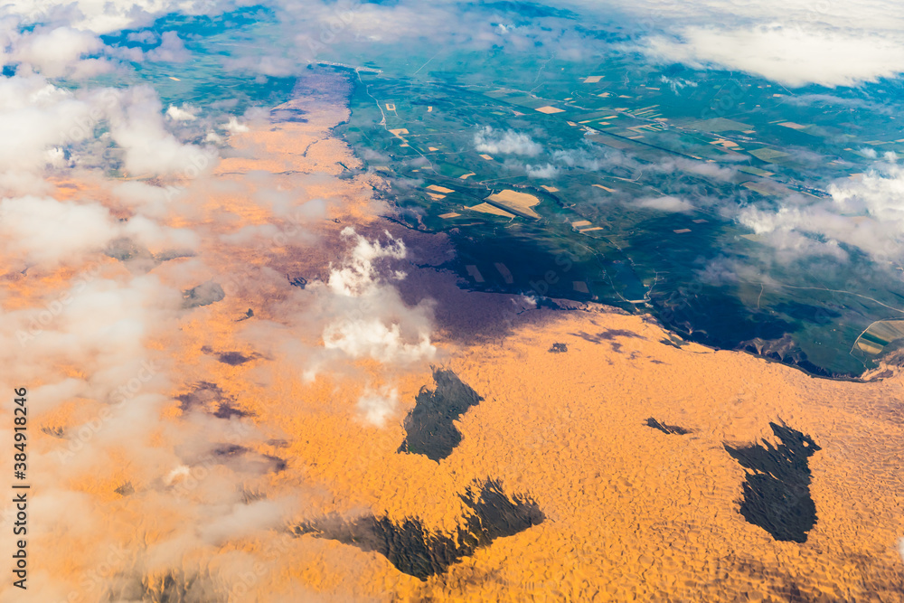 Aerial view above the clouds and mountain peaks on a sunny day.mountain view from airplane.