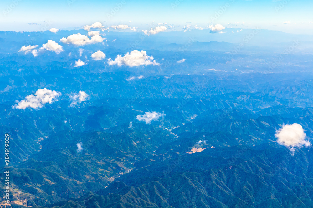 在阳光明媚的日子里俯瞰云朵和山峰。从飞机上俯瞰山景。