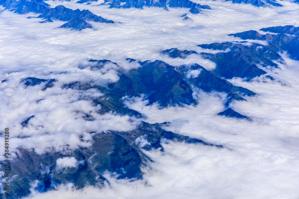 Aerial view above the clouds and mountain peaks on a sunny day.mountain view from airplane.